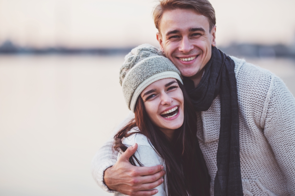 A young couple hugging and smiling, excited about the 90-day RRSP GIC Offer at Northern Birch