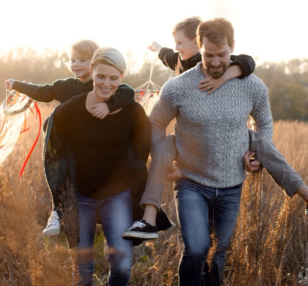 Family walking happily in a field. Take advantage of our Early Bird TFSA.